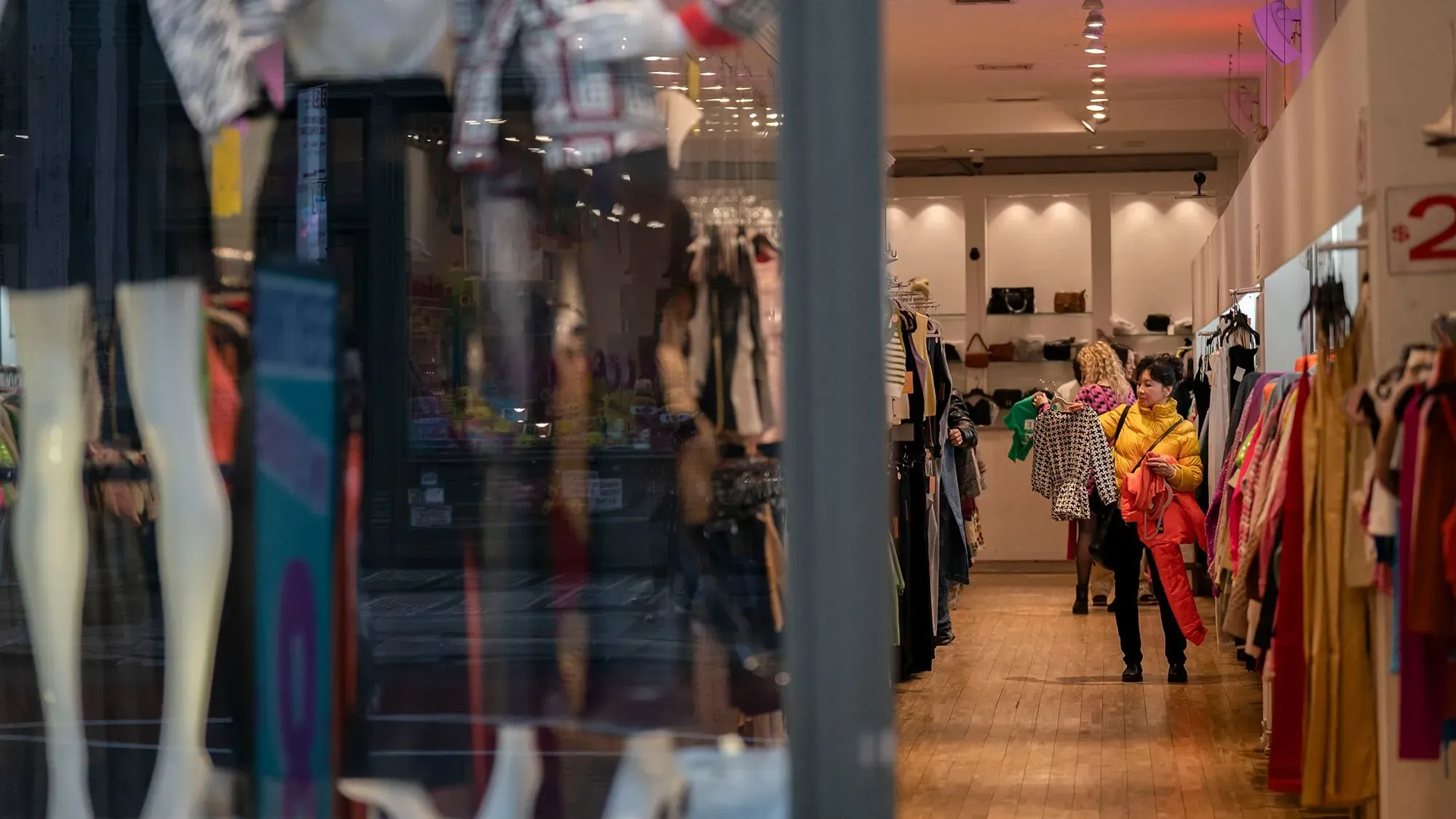 متسوقون في متجر ملابس، يعكس تراجع إنفاق المستهلكين بسبب التضخم والضغوط الاقتصادية.