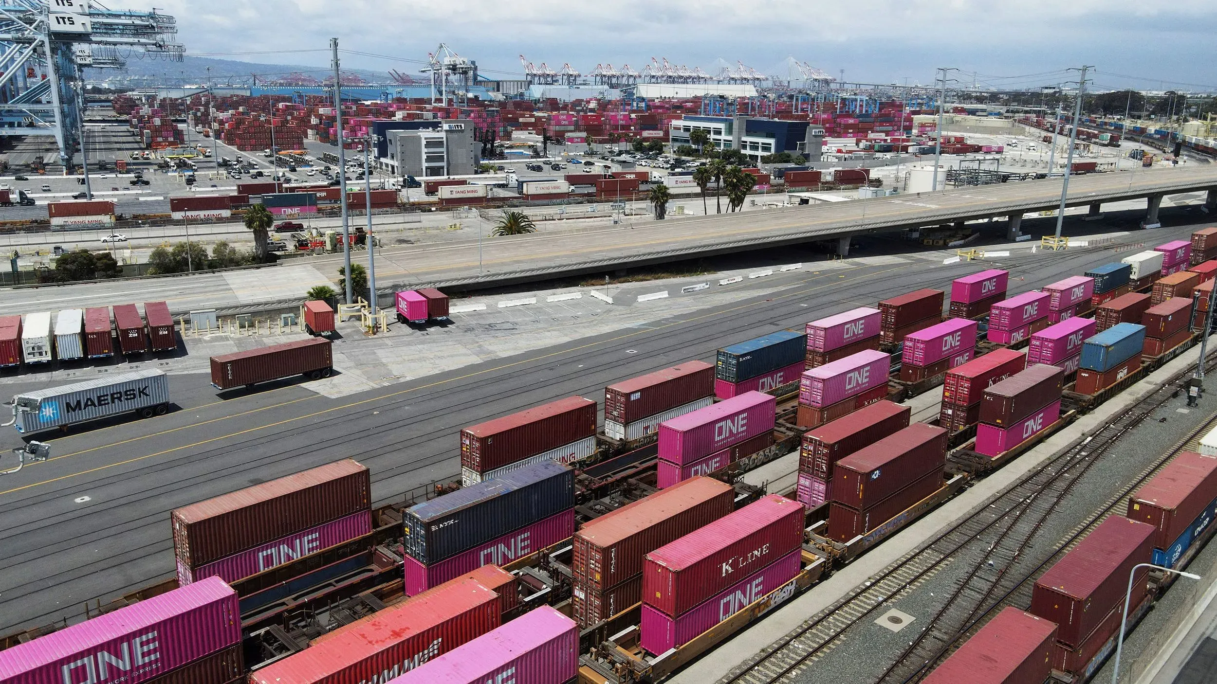 صورة لميناء لوس أنجلوس تظهر حاويات شحن ملونة متوقفة على القضبان، مما يعكس انخفاض حركة الواردات من الصين نتيجة الرسوم الجمركية.