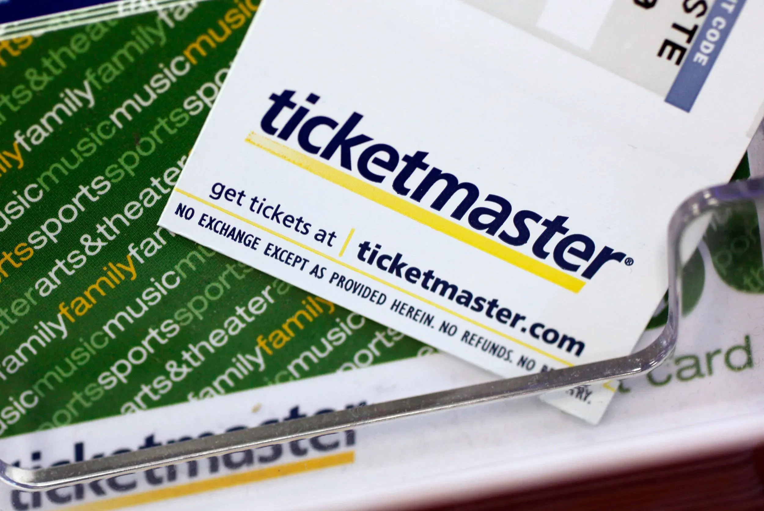 بطاقة ترويجية لشركة Ticketmaster، توضح موقعها الإلكتروني وعبارة "لا تبادل إلا كما هو موضح هنا"، تعكس قضايا التسعير والرسوم الخفية.