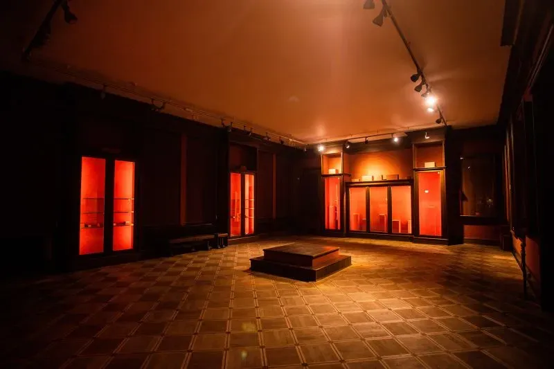 غرفة متحف مظلمة مع إضاءة حمراء، تعرض آثارًا ثقافية تم إخلاؤها لحمايتها من الأضرار بسبب الحرب في أوكرانيا.