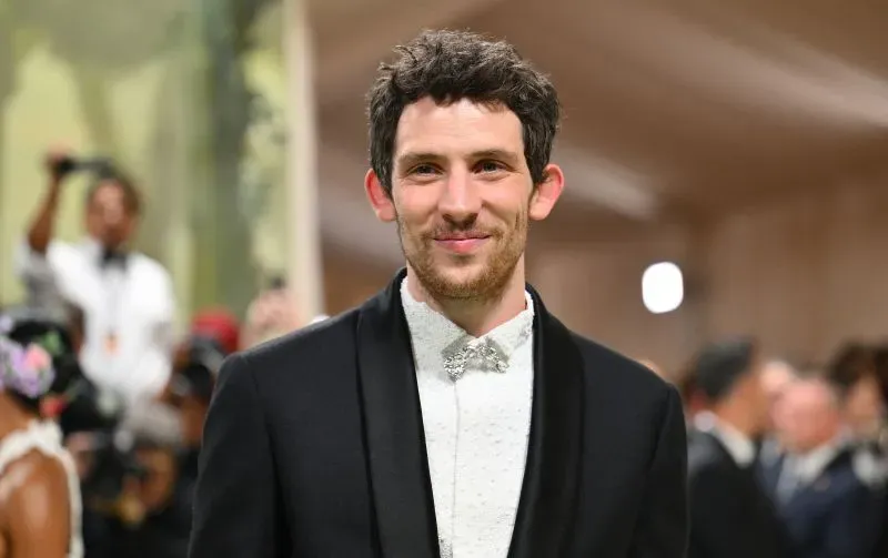 صورة لجوناثان بيلي، ممثل بريطاني يرتدي بدلة أنيقة، مبتسم في حدث رسمي، مما يعكس اهتمامه المحتمل بدور جيمس بوند القادم.