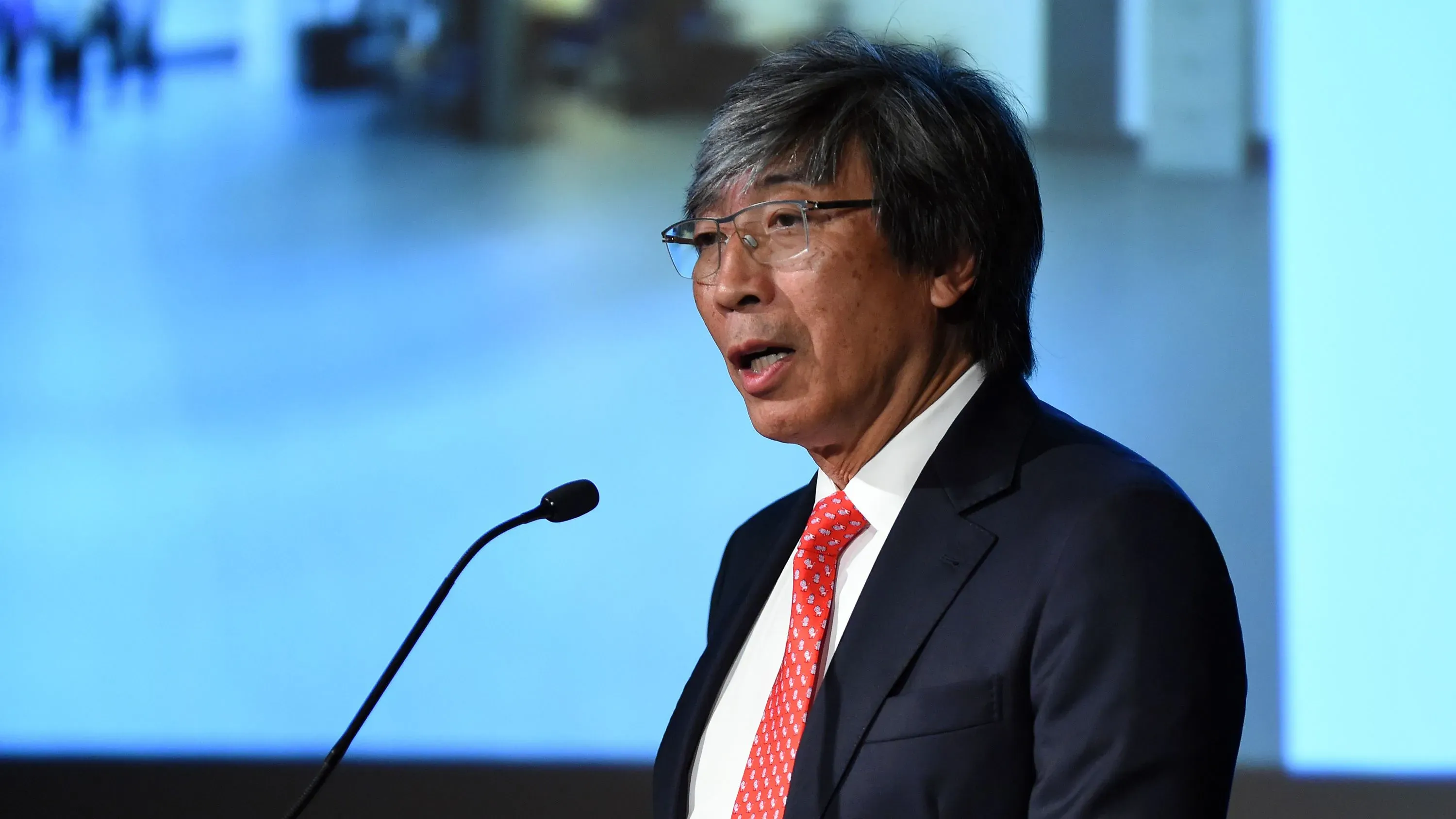 باتريك سون شيونغ، الرئيس التنفيذي لصحيفة لوس أنجلوس تايمز، يتحدث خلال مؤتمر، مع خلفية ضبابية تظهر الحضور.