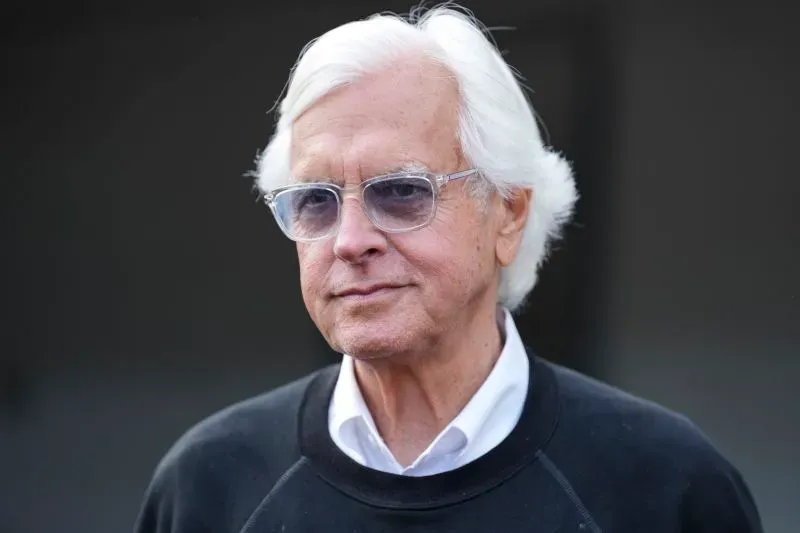 صورة لمدرب الخيول بوب بافرت، يظهر بملابس سوداء ونظارات شمسية، مع تعبير جاد، في سياق تحقيقات حول تعاطي المنشطات في سباقات الخيول.