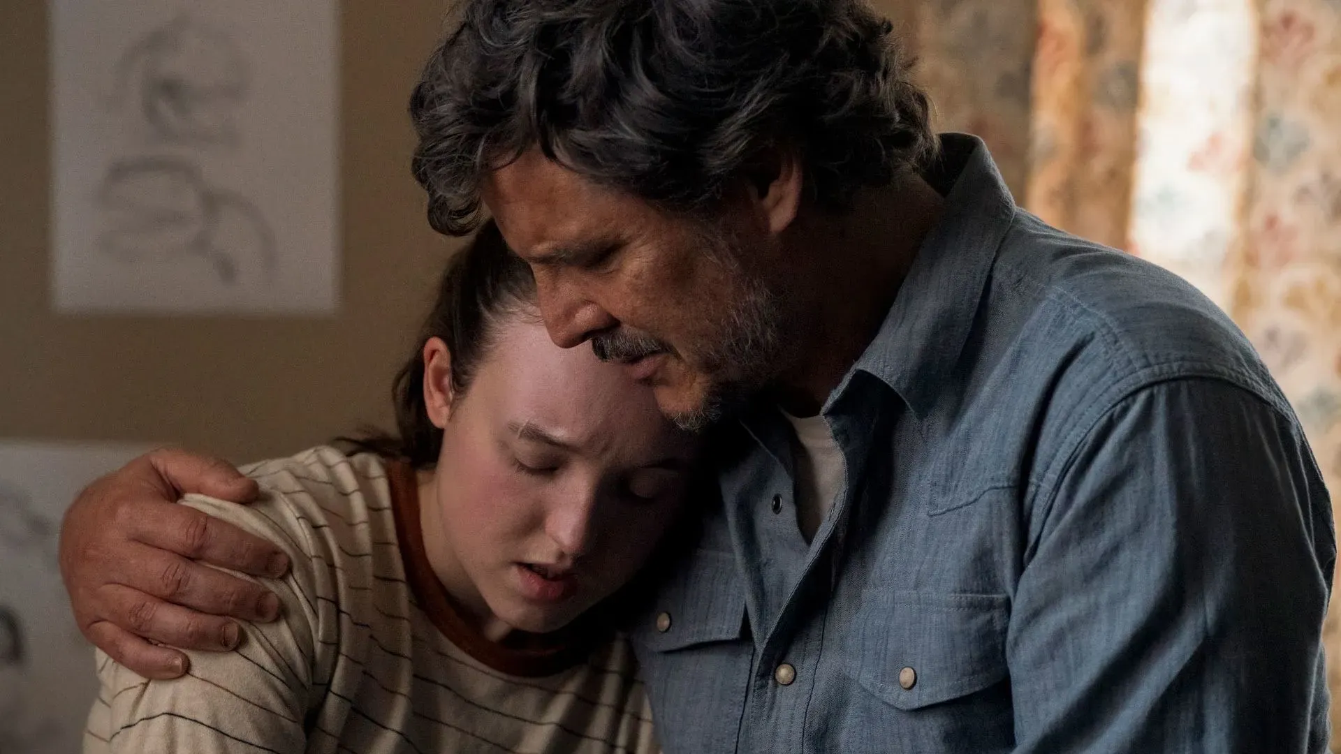 لحظة عاطفية بين جويل وإيلي، حيث يحتضنها بينما تبدو حزينة، تعكس التوترات العاطفية في مسلسل "The Last of Us".