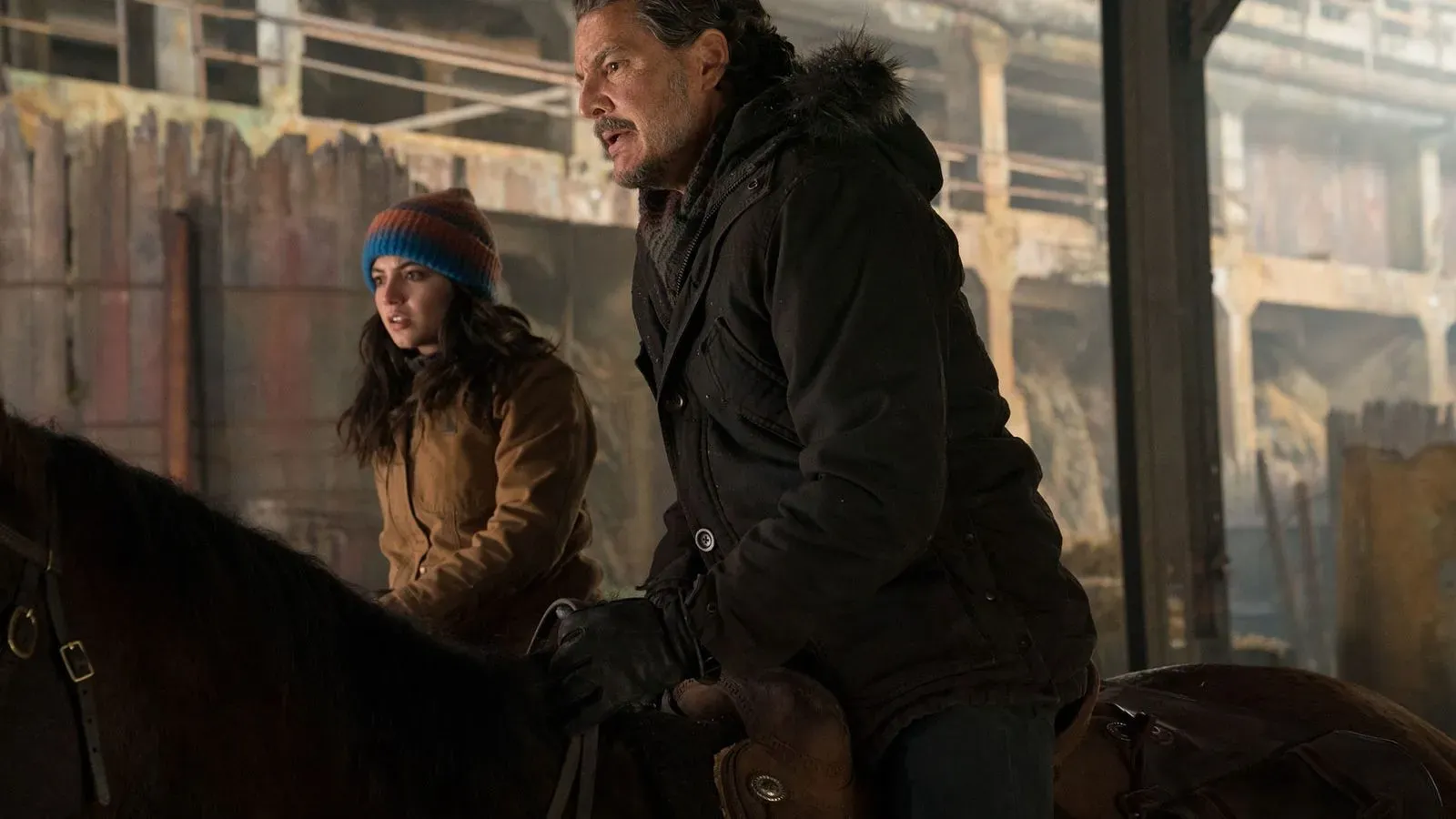 جويل وإيلي على ظهر حصان في بلدة جاكسون، مع أجواء شتوية تعكس التوترات الجديدة في الموسم الثاني من "The Last of Us".