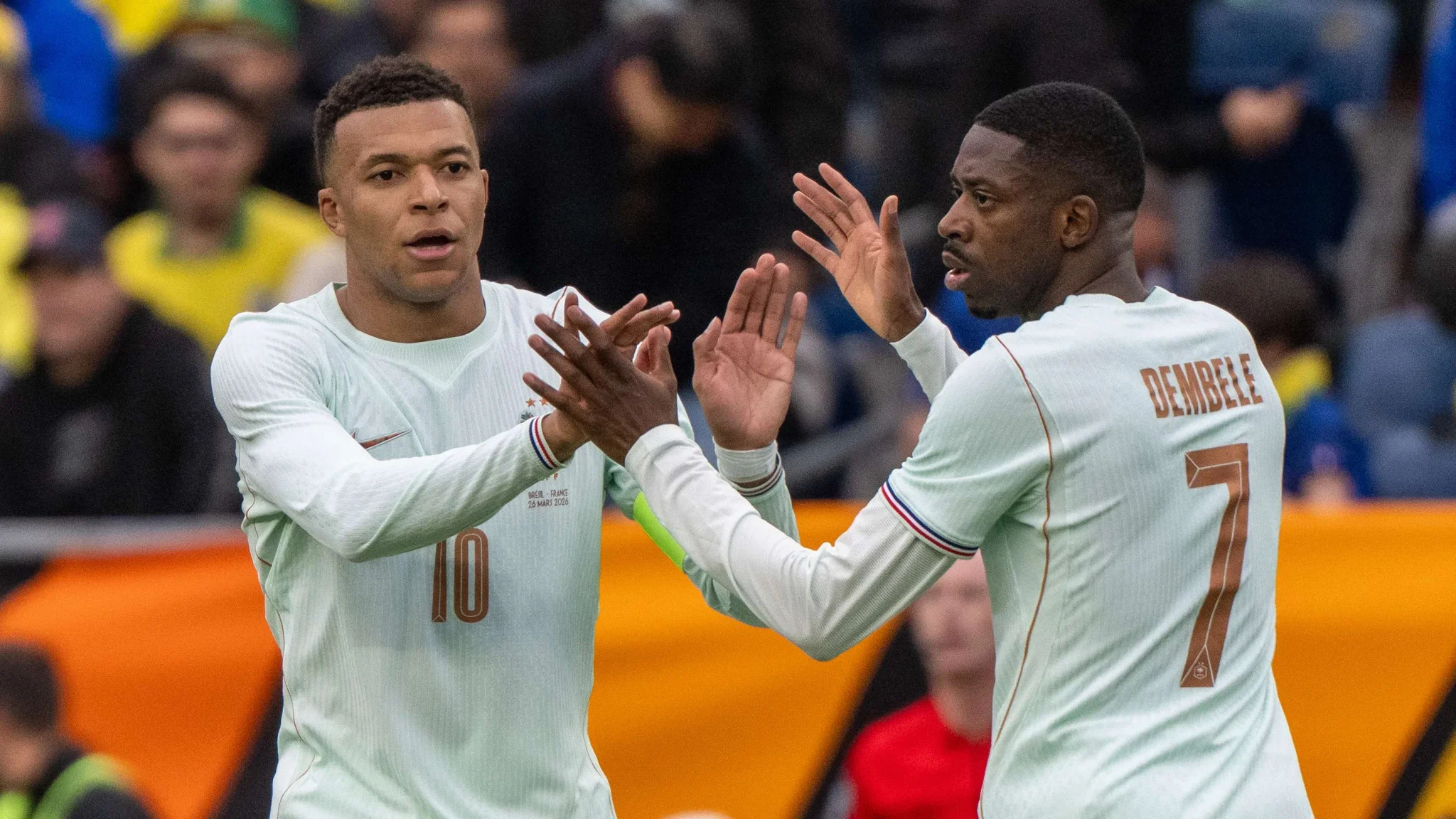 كيليان مبابي وعثمان ديمبلي يتصافحان خلال مباراة للمنتخب الفرنسي، في ظل توتر حول جائزة الكرة الذهبية قبل مباريات حاسمة.