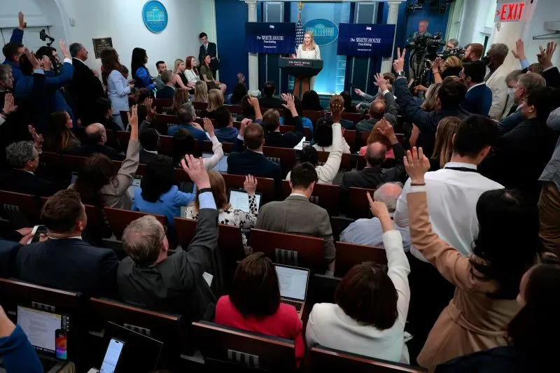 مؤتمر صحفي في البيت الأبيض، حيث ترفع مجموعة من الصحفيين أيديهم لطرح الأسئلة، بينما تتحدث المتحدثة باسم الإدارة.