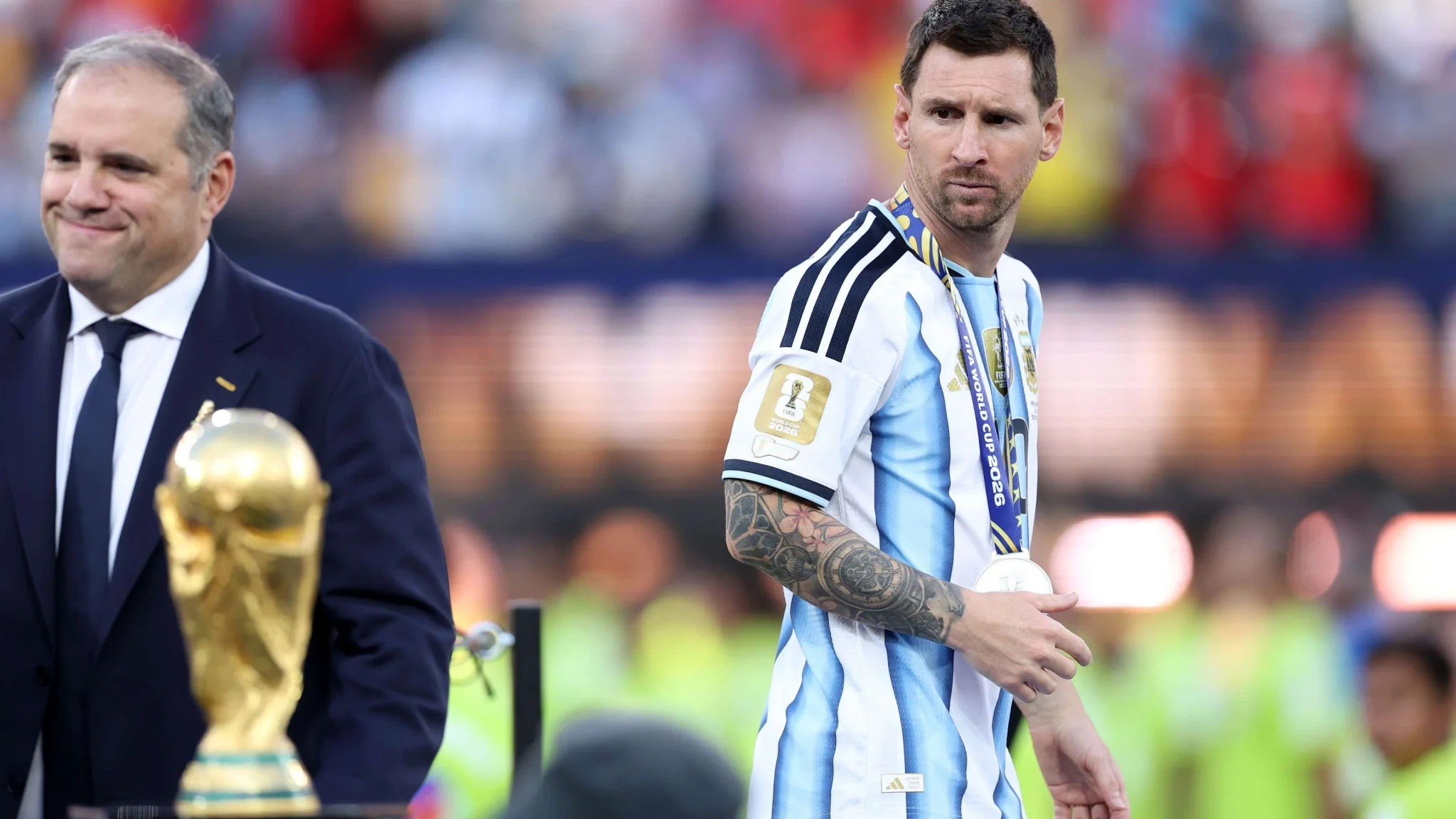 ليونيل ميسي يرتدي ميدالية كأس العالم 2026 أمام الكأس الذهبية، مع التركيز على تأثير البطولة في تعزيز قيمة العلامات التجارية.