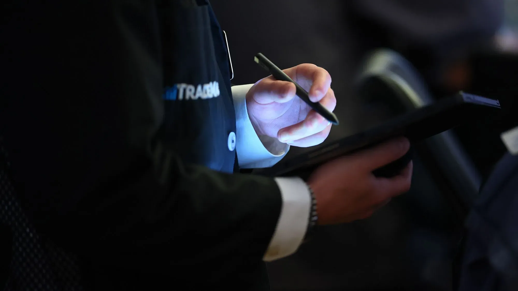 يد تكتب بمستندات مالية في بيئة تجارية، تعكس التوترات حول الضريبة الانتقامية وتأثيرها على الاستثمار الأجنبي في الولايات المتحدة.