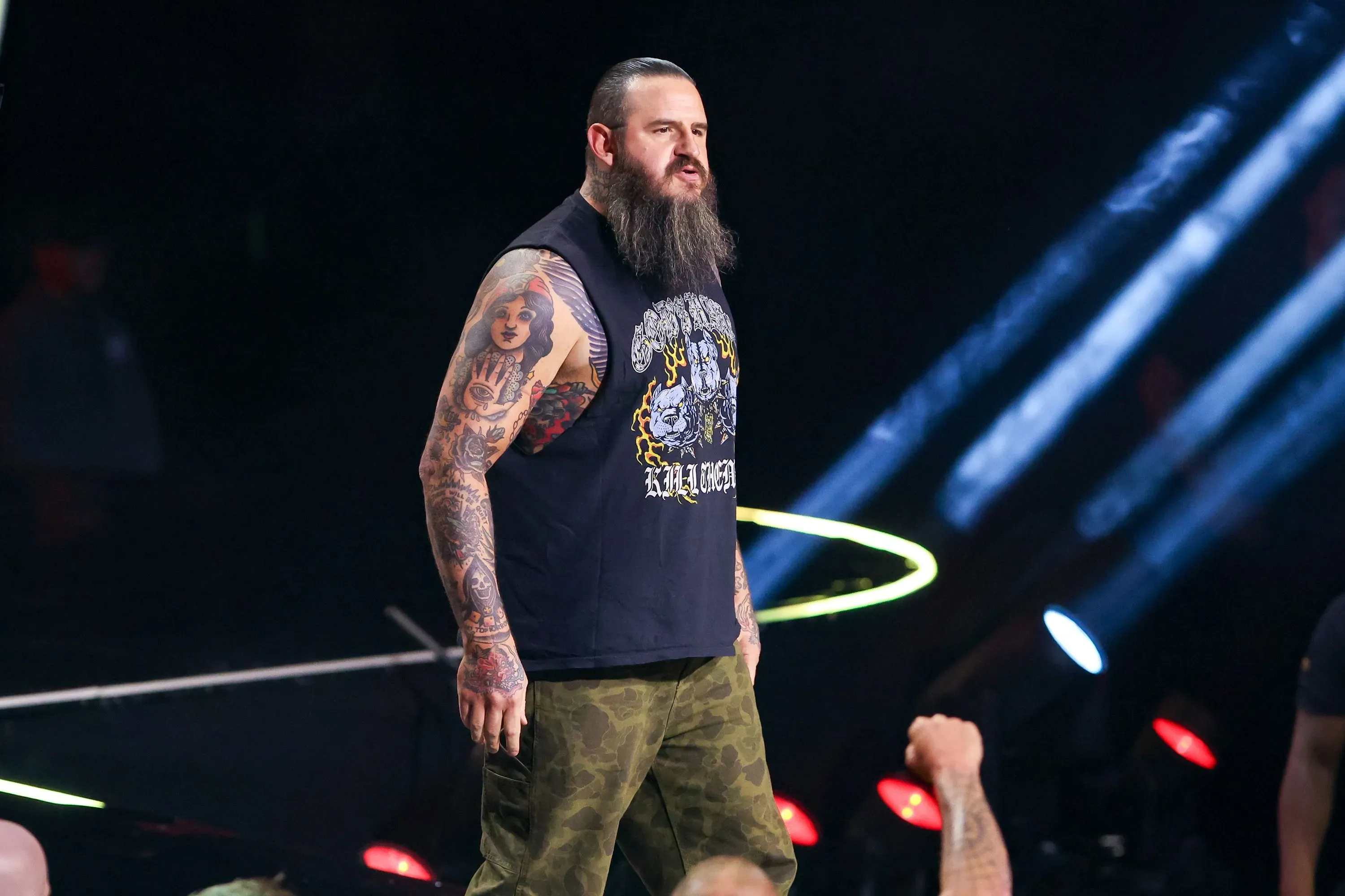 كينغ، المصارع ذو اللحية الرمادية والوشوم، يقف في الحلبة بينما يهتف الجمهور بحماس في مباراة مصارعة في لاس فيجاس.