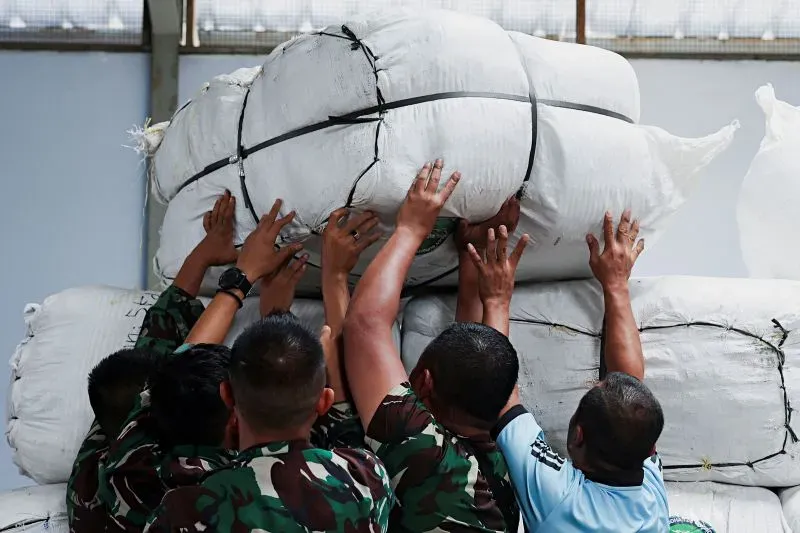 متطوعون يحملون أكياس المساعدات الإنسانية في موقع توزيع، وسط جهود الإغاثة بعد الزلزال المدمر الذي ضرب ميانمار.