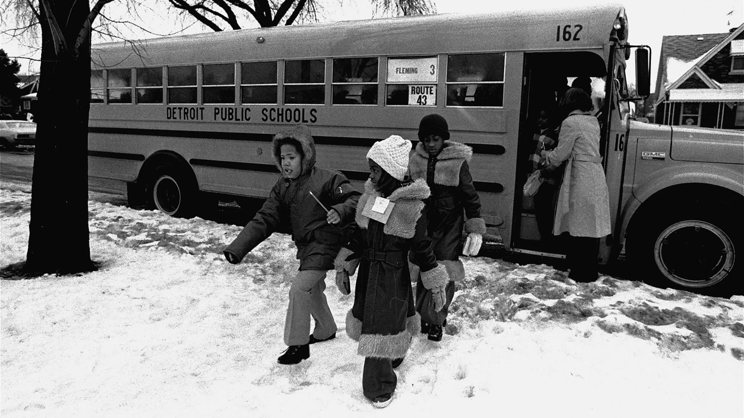 مجموعة من الأطفال يخرجون من حافلة مدرسية في ديترويت خلال فصل الشتاء، في سياق جهود دمج المدارس العامة بعد حكم ميليكن.