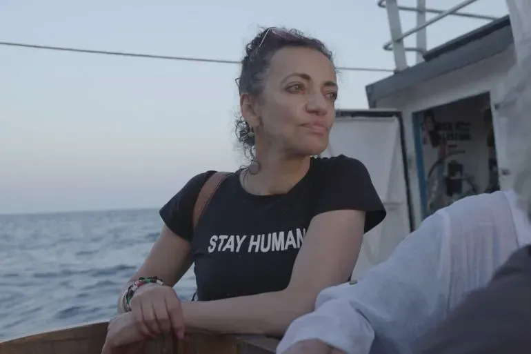 هويدا عرّاف، ناشطة في حركة كسر الحصار البحري على غزة، ترتدي قميصًا مكتوبًا عليه "ابق إنسانيًا" أثناء تواجدها على متن السفينة حنظلة.