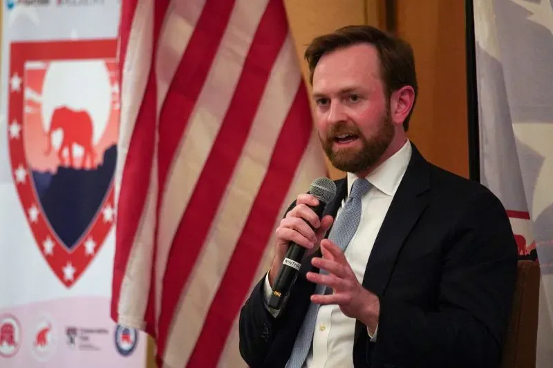 رئيس لجنة التجارة الفيدرالية أندرو فيرجسون يتحدث خلال فعالية، مع العلم الأمريكي خلفه، عن استمرارية إرشادات الاندماج لعام 2023.