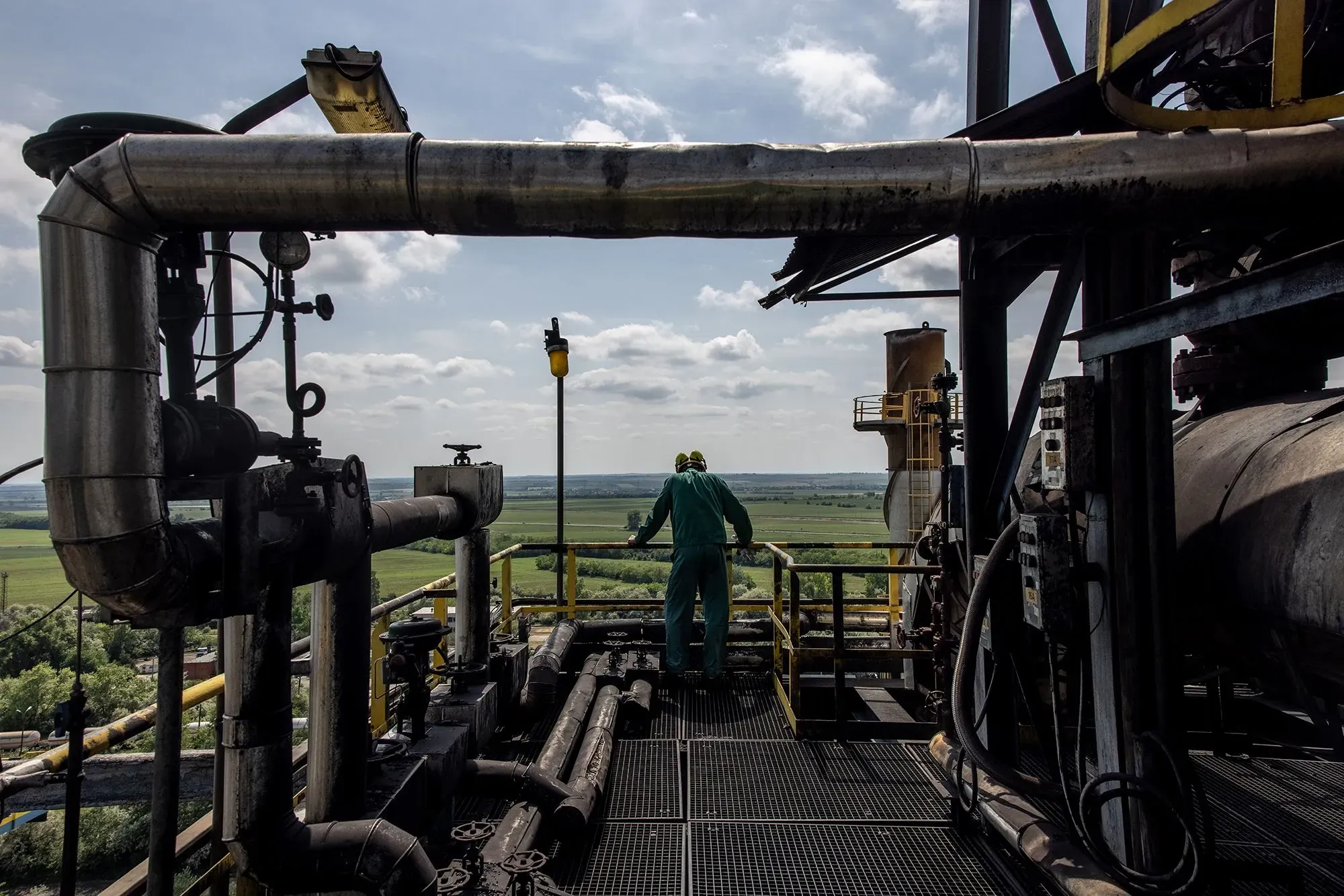 عامل في منشأة صناعية يراقب خطوط الأنابيب في مشهد يعكس تأثير التجارة العالمية مع روسيا في ظل الأزمات الحالية.