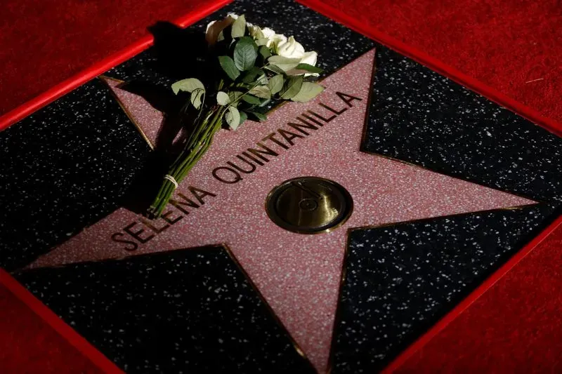 نجمة سيلينا كوينتانيلا على ممر المشاهير، مع باقة من الزهور البيضاء، تكريمًا لذكرى المغنية الشهيرة "ملكة تيجانو".