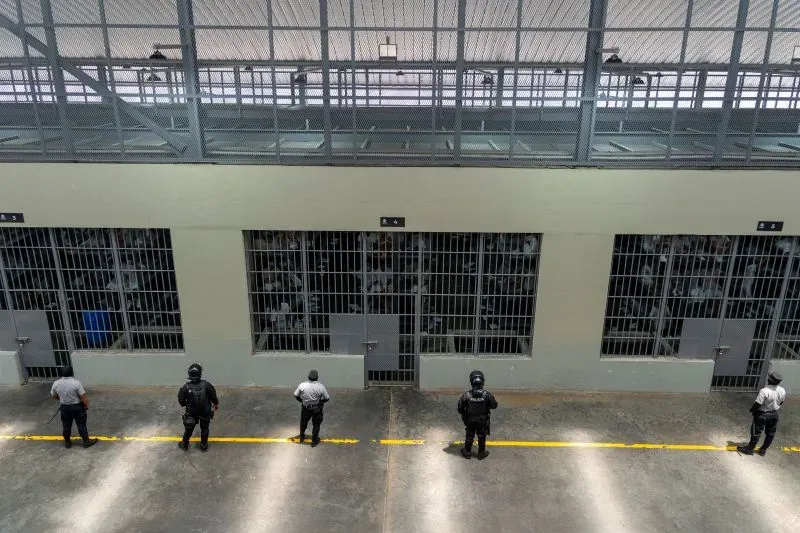 صورة تظهر حراس مسلحين يقفون أمام زنازين في سجن سيكوت، حيث يُحتجز أعضاء عصابات مثل MS-13 وشارع 18.