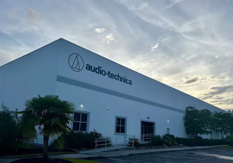 مستودع شركة Audio-Technica في منطقة التجارة الخارجية في سان دييغو، مع سماء ملبدة بالغيوم، يمثل نقطة استراتيجية لتجنب الرسوم الجمركية.