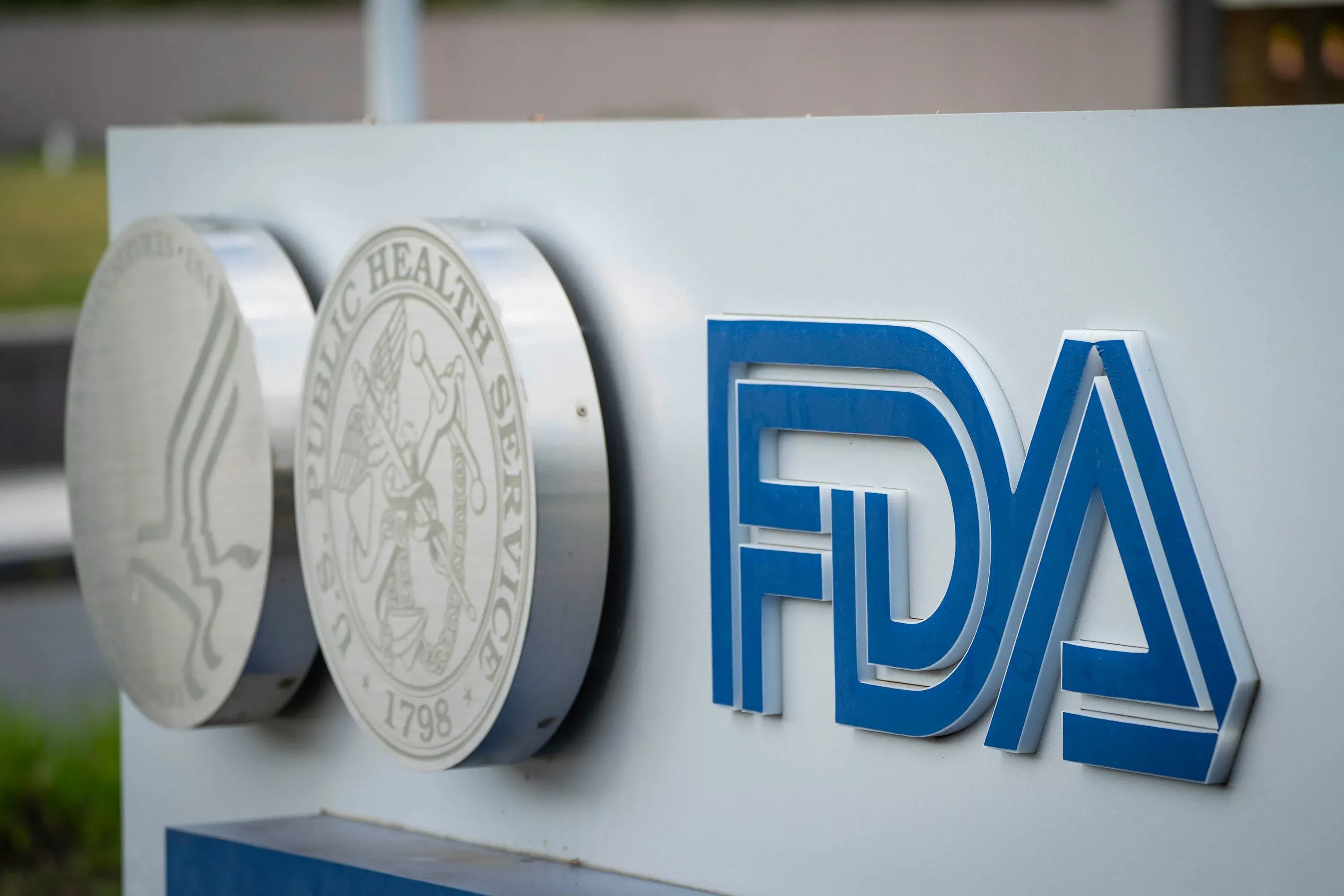 شعار إدارة الغذاء والدواء الأمريكية (FDA) مع تفاصيل حول اعتماد لقاحات كوفيد-19 الجديدة للأشخاص الأكثر عرضة للخطر.