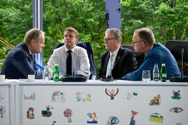 اجتماع قادة أوروبيين في قمة، يتوسطهم الرئيس ماكرون، حيث يناقشون قضايا الأمن والتعاون الأوروبي.