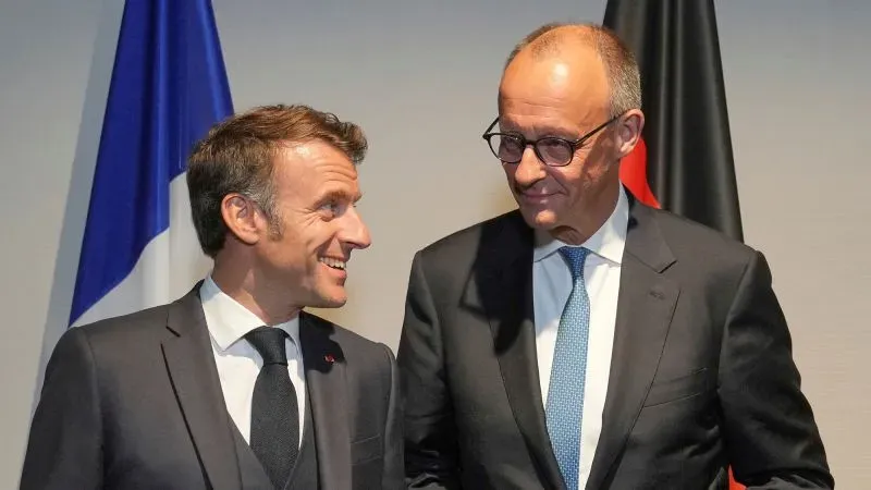 ماكرون وميرتس يتبادلان الابتسامات خلال لقاء في قصر الإليزيه، يعكسان التعاون الفرنسي الألماني في قضايا الأمن الأوروبي.