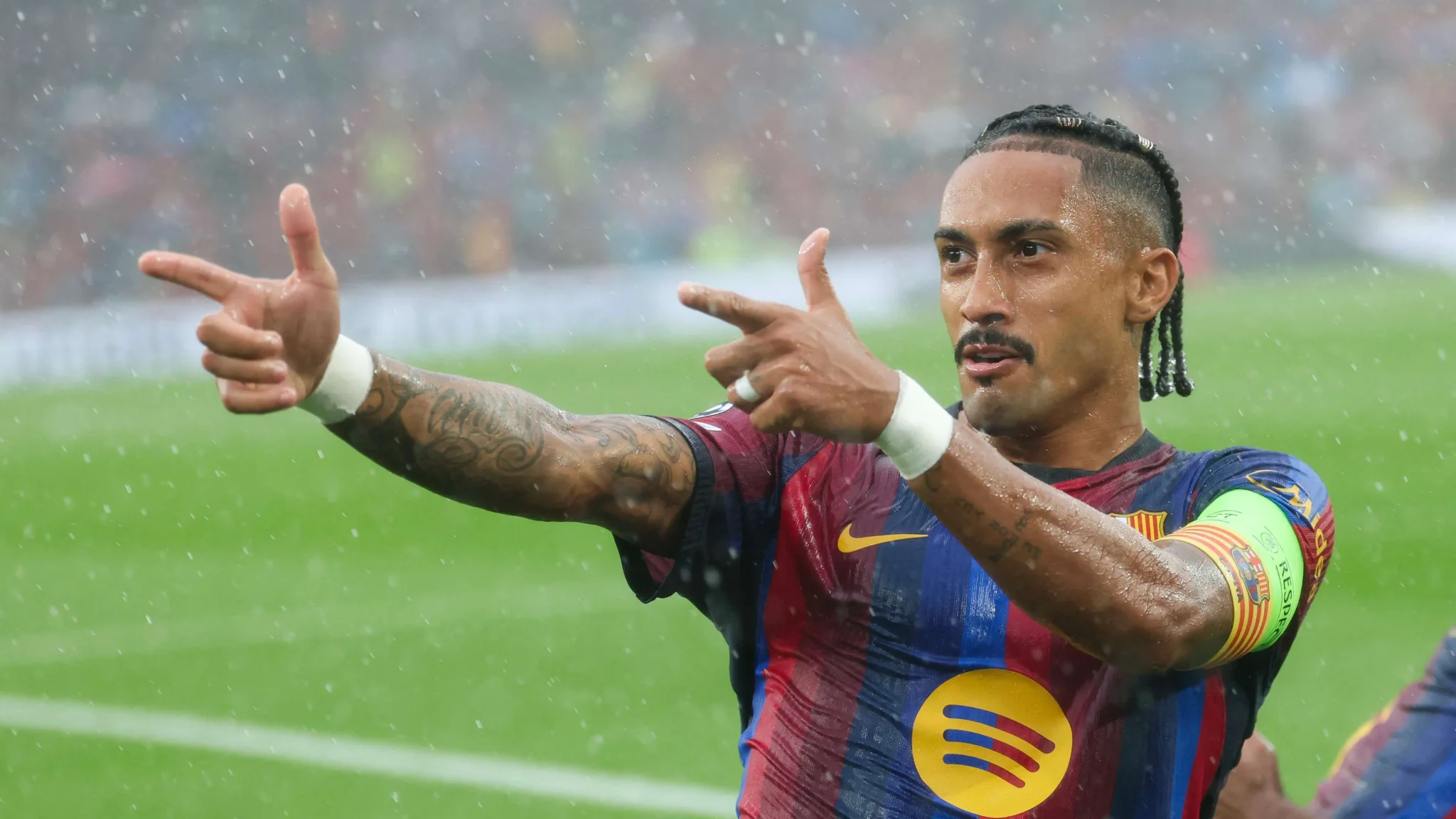 رافينيا قائد برشلونة يحتفل بهدفه في مباراة تحت المطر، مع أداء مميز في دوري أبطال أوروبا ودوري الليغا.