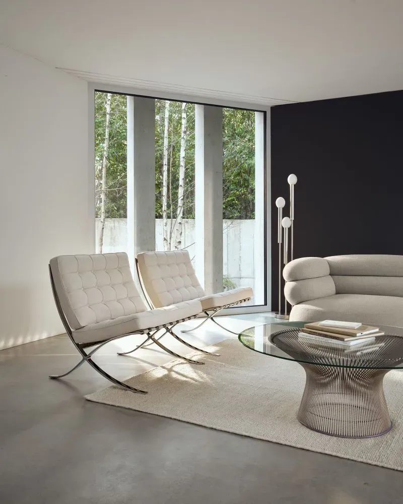 مجموعة أثاث برشلونة الشهيرة، تتضمن كراسي بتصميم عصري وأنيق، مع تفاصيل من الفولاذ والمخمل، تعكس إرث ميس فان دير روه.