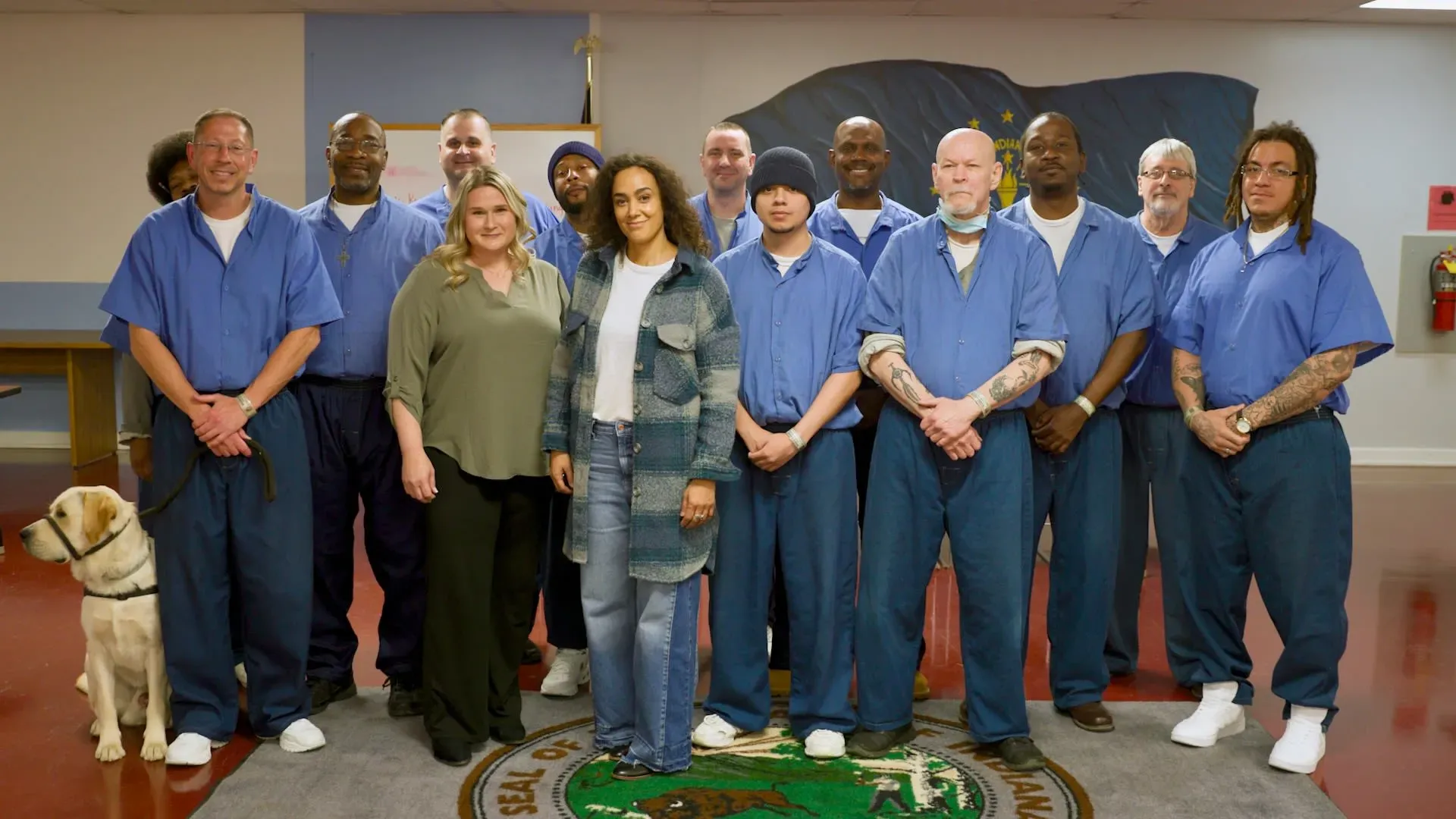 ديبرا دي فينيز مع مجموعة من السجناء في ورشة الكتابة الإبداعية، حيث يشاركون تجاربهم ويعملون على تطوير مهاراتهم الكتابية.