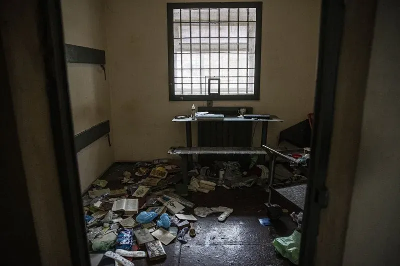 غرفة مدمرة مليئة بالفوضى، تحتوي على كتب وأغراض متناثرة، تعكس الظروف القاسية تحت الاحتلال الروسي في أوكرانيا.