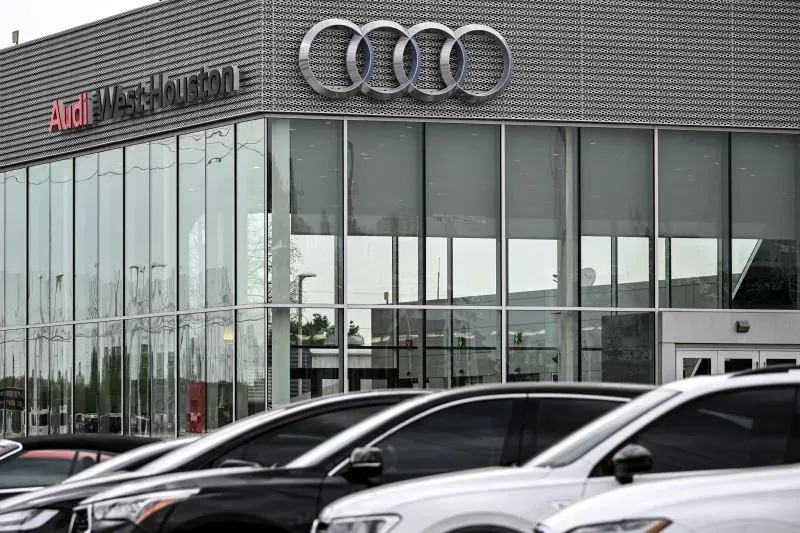 واجهة معرض سيارات أودي في هيوستن، مع عرض عدد من السيارات في المقدمة، تشير إلى تأثير التعريفات الجمركية على قطاع الخدمات الأمريكي.