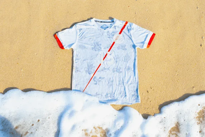 قميص كرة القدم الجديد لجزر مارشال، مزخرف بألوان العلم وصور نباتات وحيوانات الجزيرة، يرمز للتوعية بتغير المناخ.