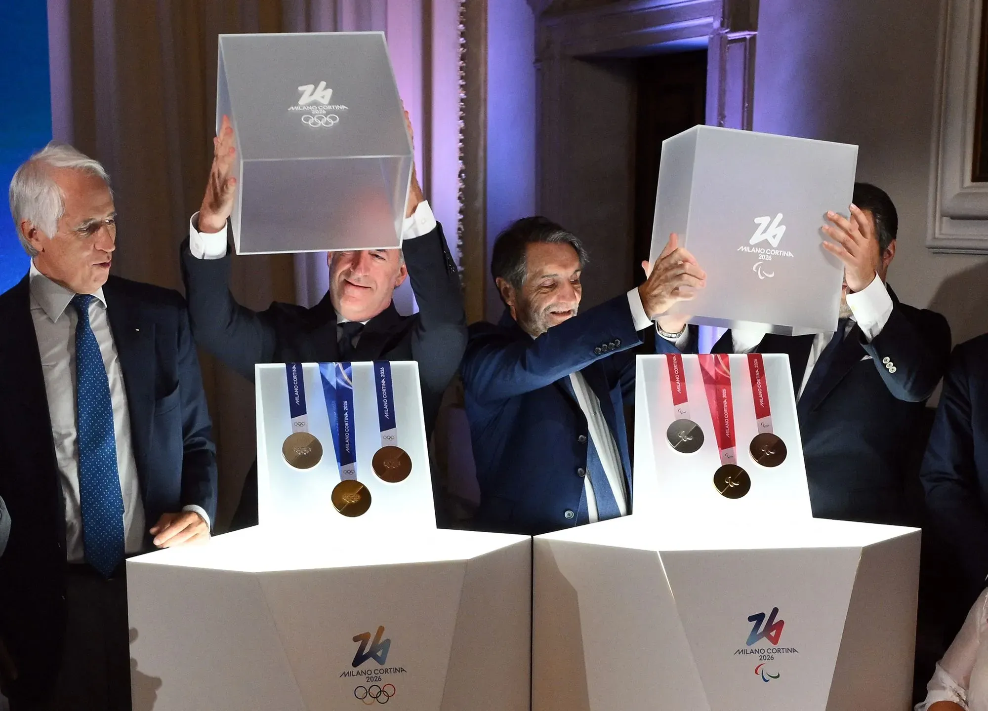 ميداليات أولمبياد الشتاء في إيطاليا تُعرض في حدث رسمي، مع وجود فائزين يحملون الميداليات الذهبية والفضية والبرونزية.