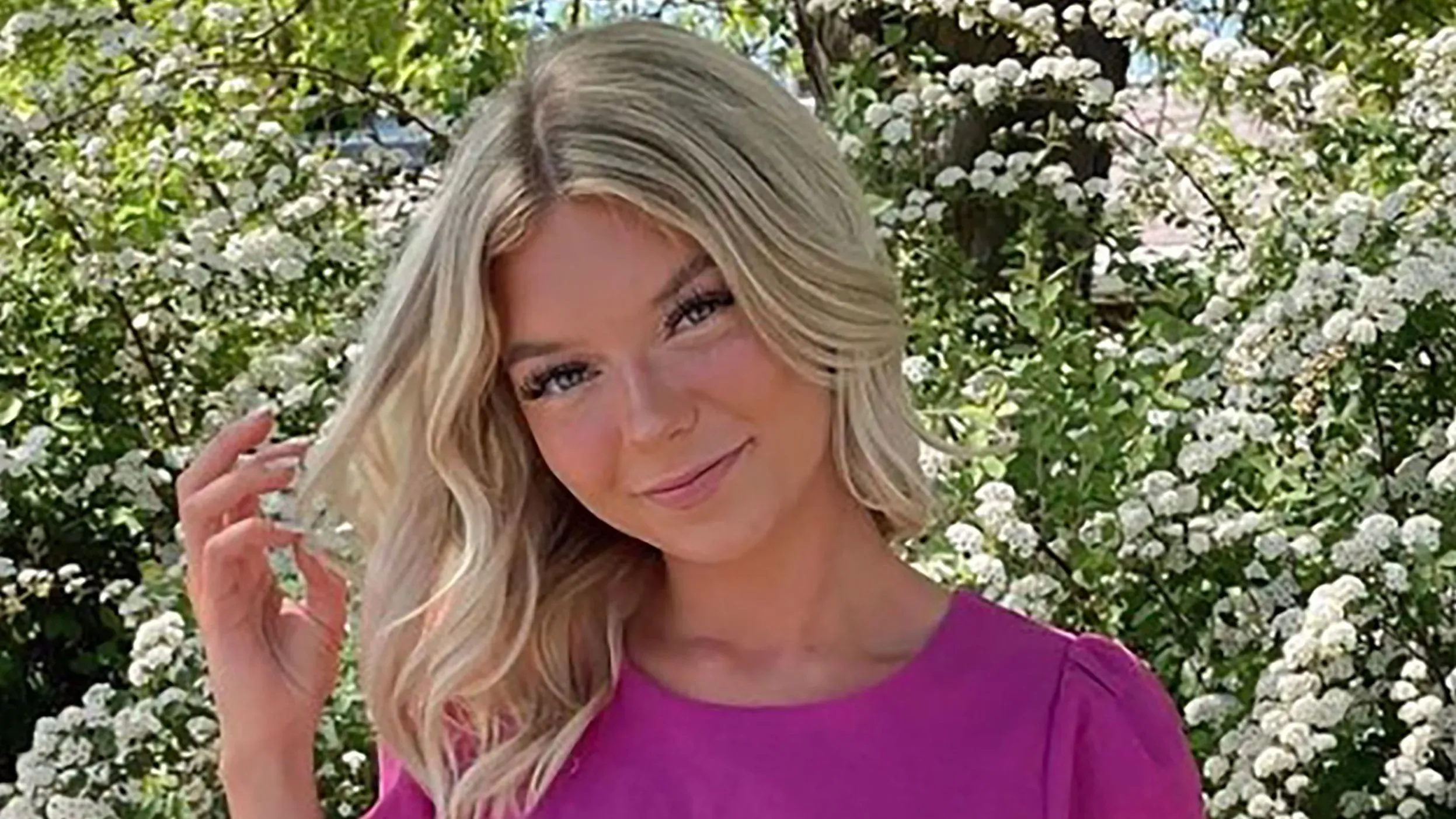 صورة لطالبة شابة ذات شعر أشقر طويل ترتدي قميصًا ورديًا، تتوسط أزهار بيضاء، حيث تمثل ضحية في قضية قتل في جامعة أيداهو.