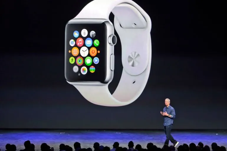 تيم كوك يتحدث على المسرح أمام شاشة تعرض ساعة آبل، مع التركيز على الابتكارات التي حققتها الشركة خلال فترة قيادته.