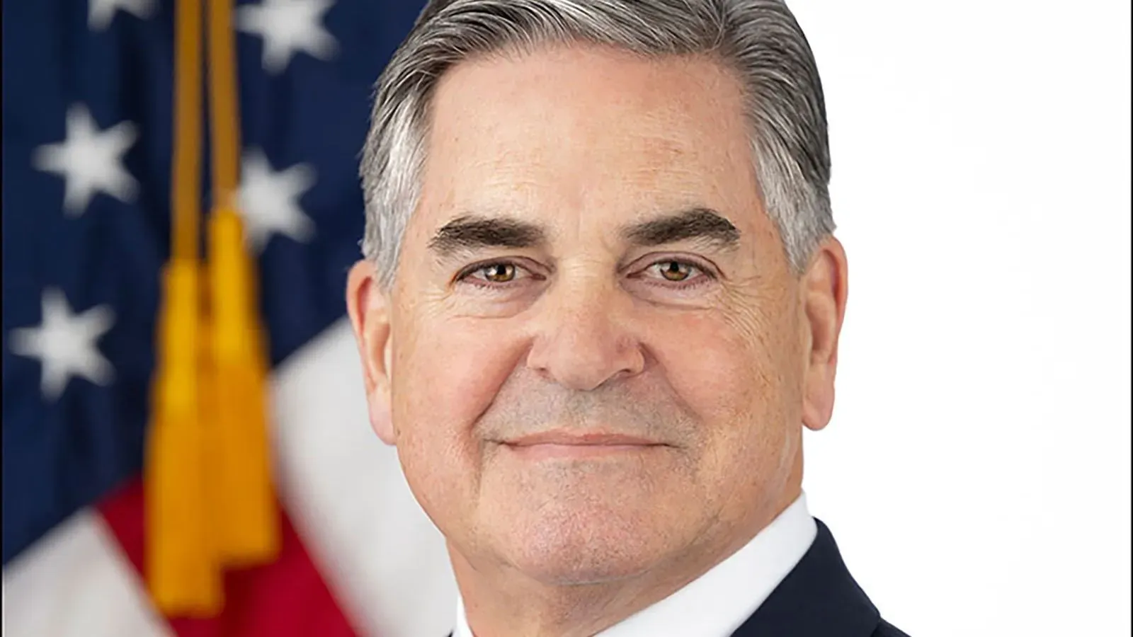 استقال توماس كوري، مساعد وزير الصحة الأمريكي، بشكل مفاجئ بعد خلافات داخل الوزارة، مع خلفية العلم الأمريكي.