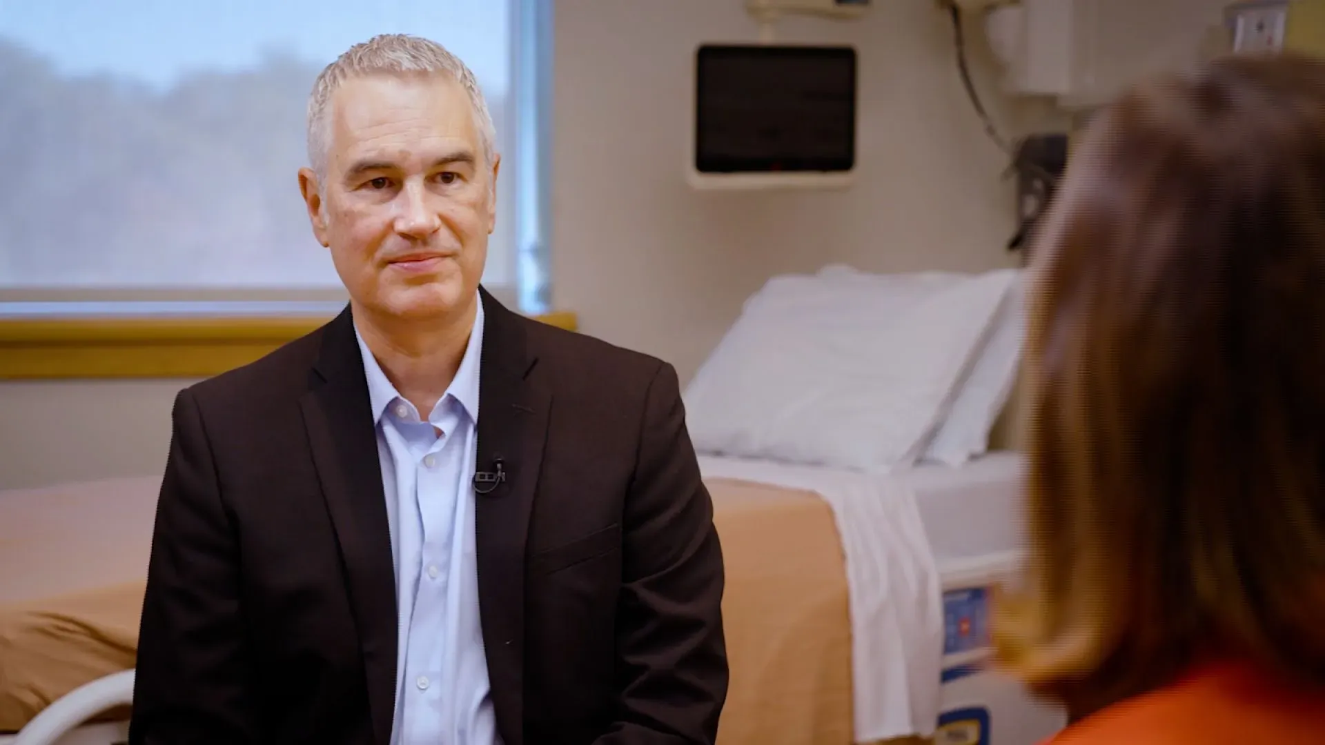 دكتور كيفن هول يتحدث في مقابلة حول أبحاثه في التغذية وتأثير الأغذية فائقة المعالجة على الصحة، مع خلفية سريرية.