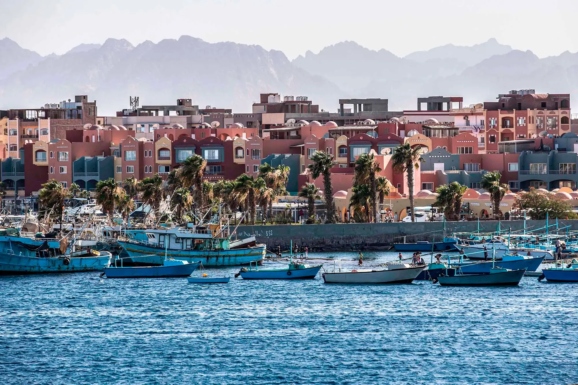 منظر لمدينة الغردقة المصرية، يظهر المراكب في المياه مع خلفية المباني الملونة والنخيل، حيث وقعت حادثة لدغة الثعبان لسائح ألماني.