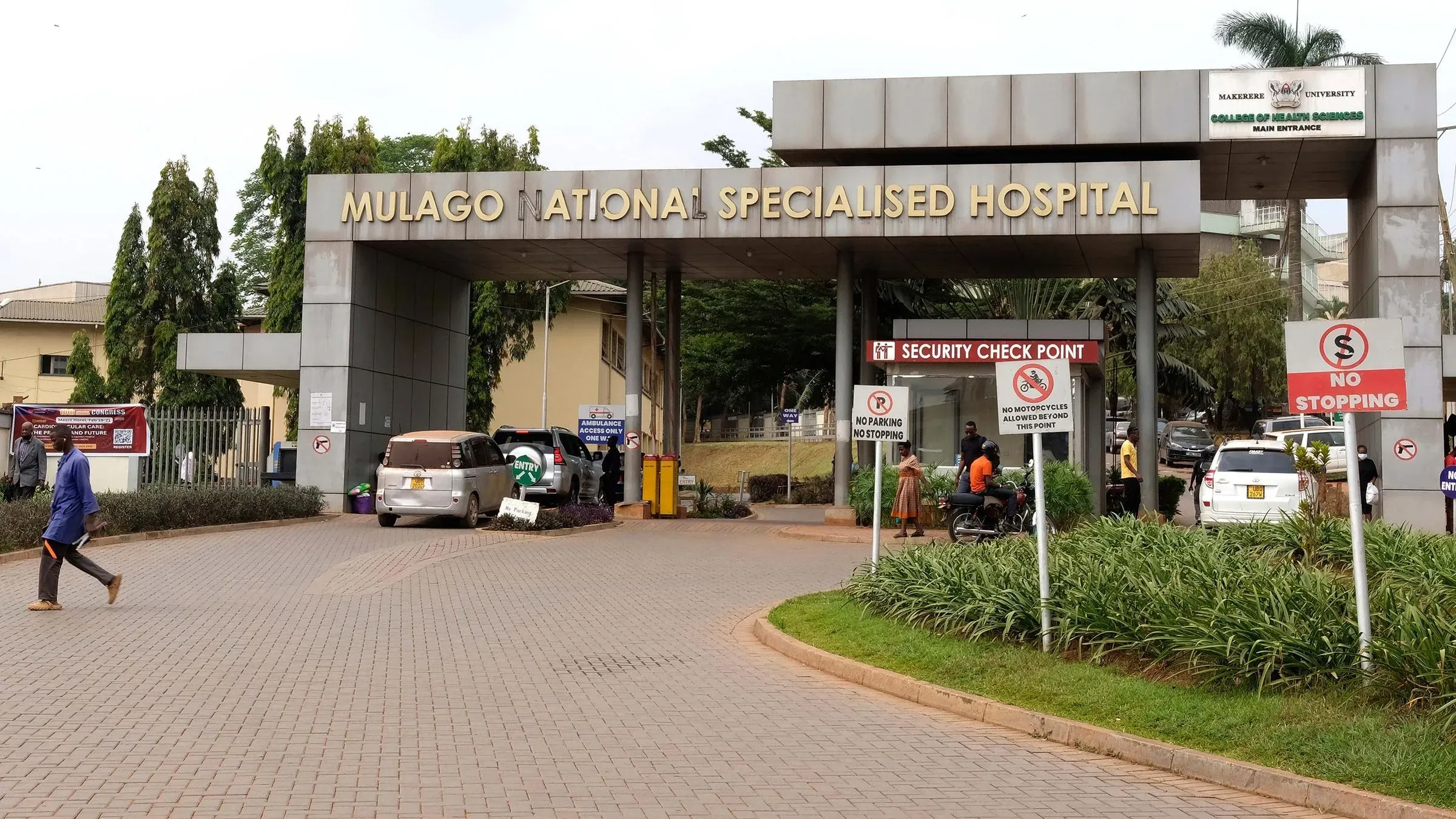 مدخل مستشفى مولاغو الوطني المتخصص في أوغندا، حيث تم الإعلان عن تفشي مرض فيروس السودان. تظهر لافتات تحذيرية وإجراءات أمنية.