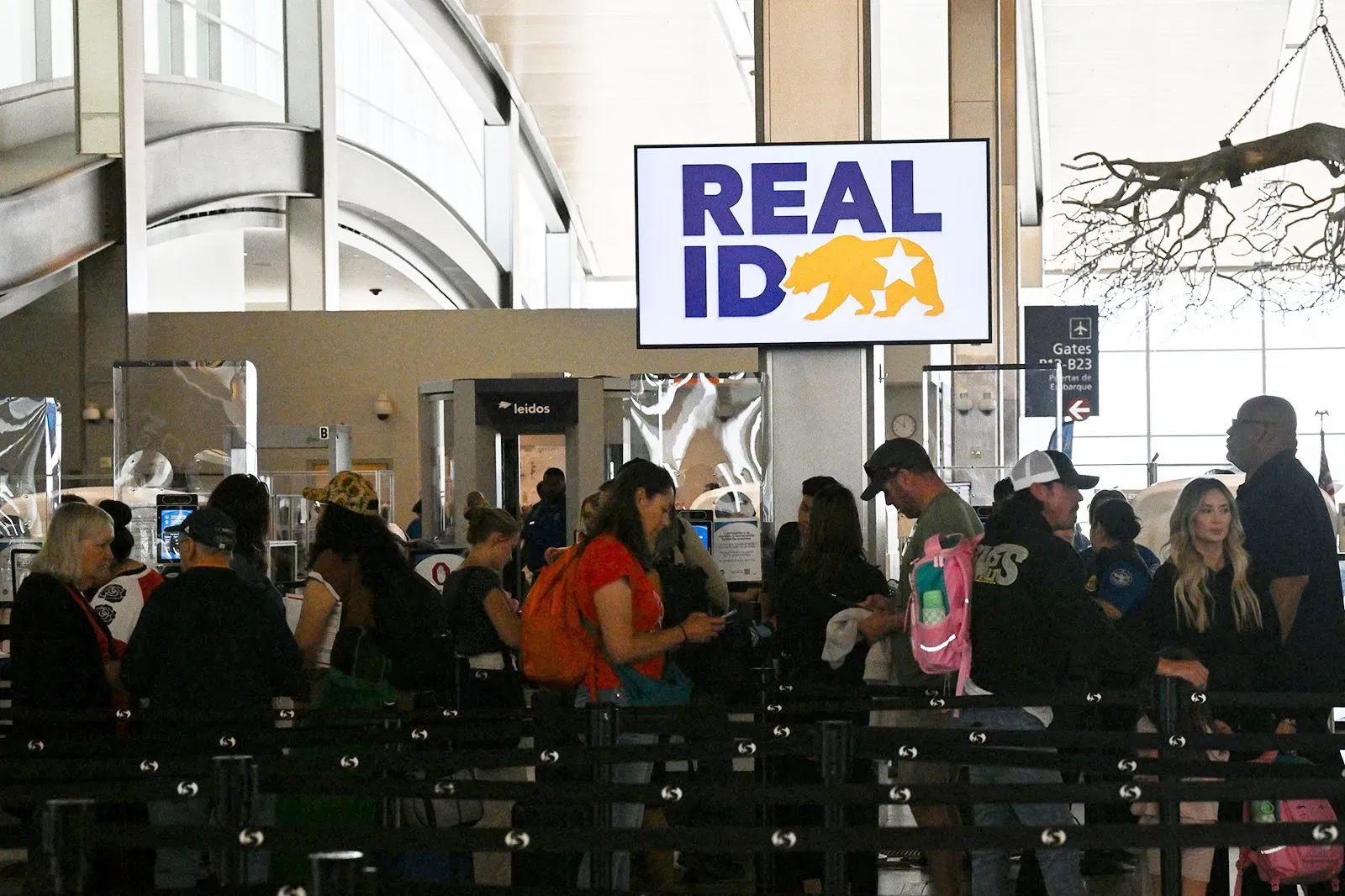 طابور من المسافرين في مطار أمام شاشة تعرض شعار "REAL ID"، في سياق تطبيق معايير الهوية الجديدة في الولايات المتحدة.