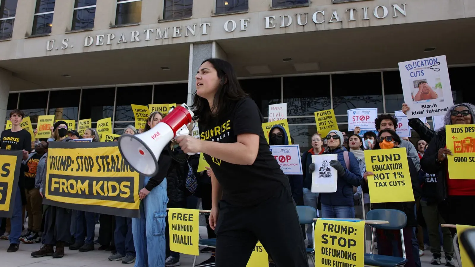 محتجون أمام وزارة التعليم الأمريكية يحملون لافتات تدعو إلى تمويل التعليم ووقف تخفيضات الميزانية، خلال مظاهرة ضد إدارة ترامب.