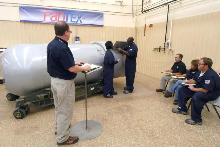 مجموعة من العاملين في وكالة الأمن النووي الأمريكية يتدربون على صيانة الأسلحة النووية في منشأة بانتيكس، مع وجود مشرف يقوم بتدوين الملاحظات.