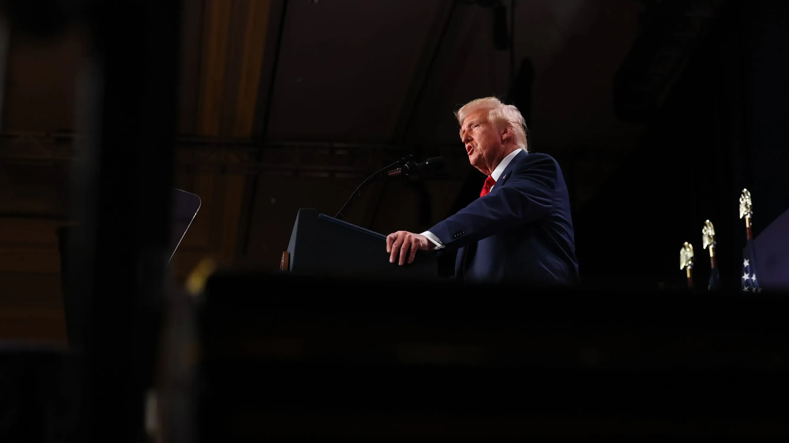 خطاب من خلف المنصة للرئيس ترامب، حيث يتحدث عن العودة إلى العمل الفيدرالي والتغييرات المرتبطة بالموظفين الحكوميين.