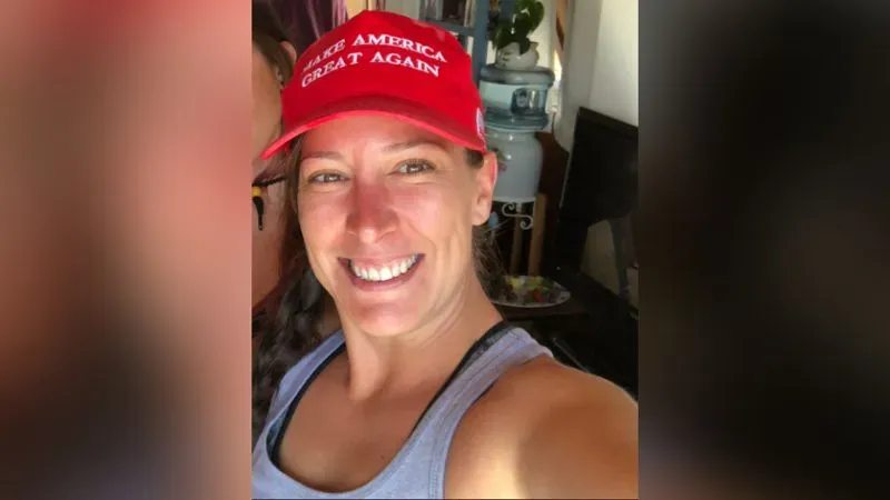 امرأة مبتسمة ترتدي قبعة حمراء مكتوب عليها "اجعل أمريكا عظيمة مرة أخرى"، تعكس تأييدها لدونالد ترامب.