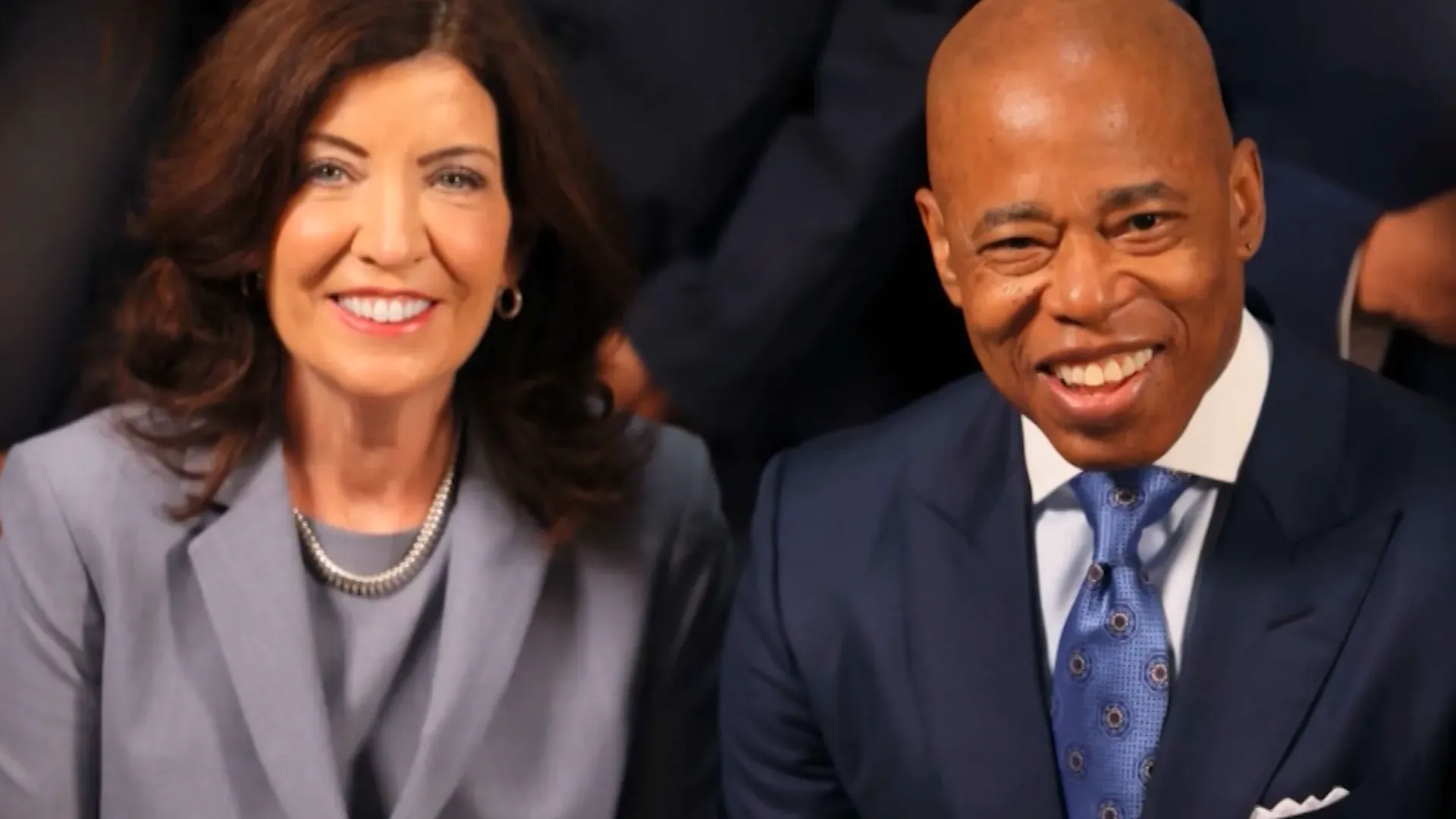 صورة تجمع حاكمة نيويورك كاثي هوشول وعمدة نيويورك إريك آدامز، مبتسمين معًا في مناسبة رسمية، تعكس التعاون بين الحكومة المحلية.