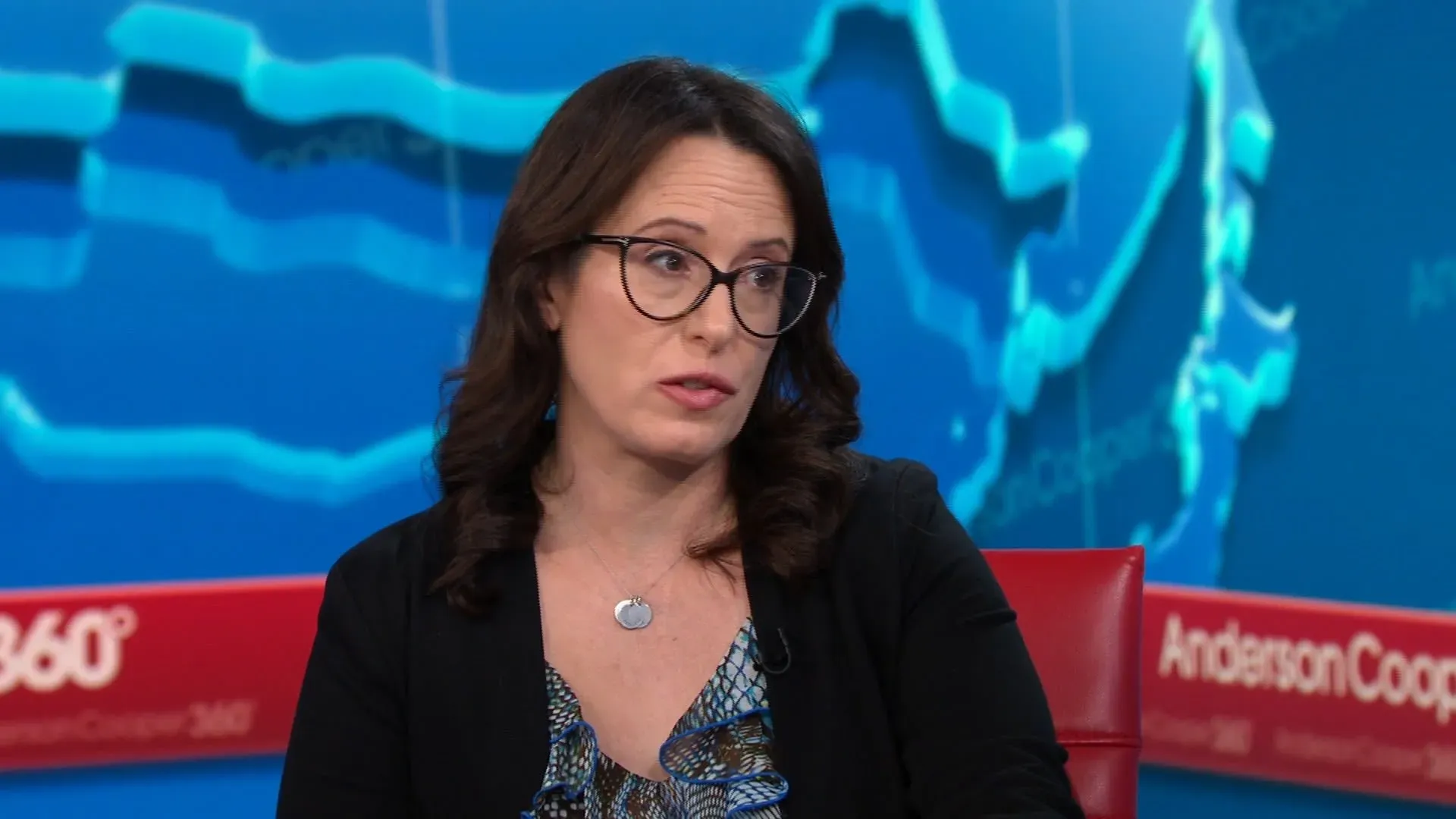 امرأة ترتدي نظارات وتظهر في مقابلة تلفزيونية، تتحدث عن قضايا قانونية تتعلق بإدارة ترامب، مع خلفية توضح الرسوم البيانية.