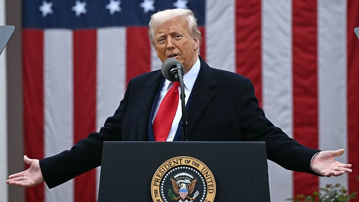 خطاب للرئيس دونالد ترامب أثناء مؤتمر صحفي، مع العلم الأمريكي خلفه، حيث يتحدث عن استراتيجيات التعريفات الجمركية.