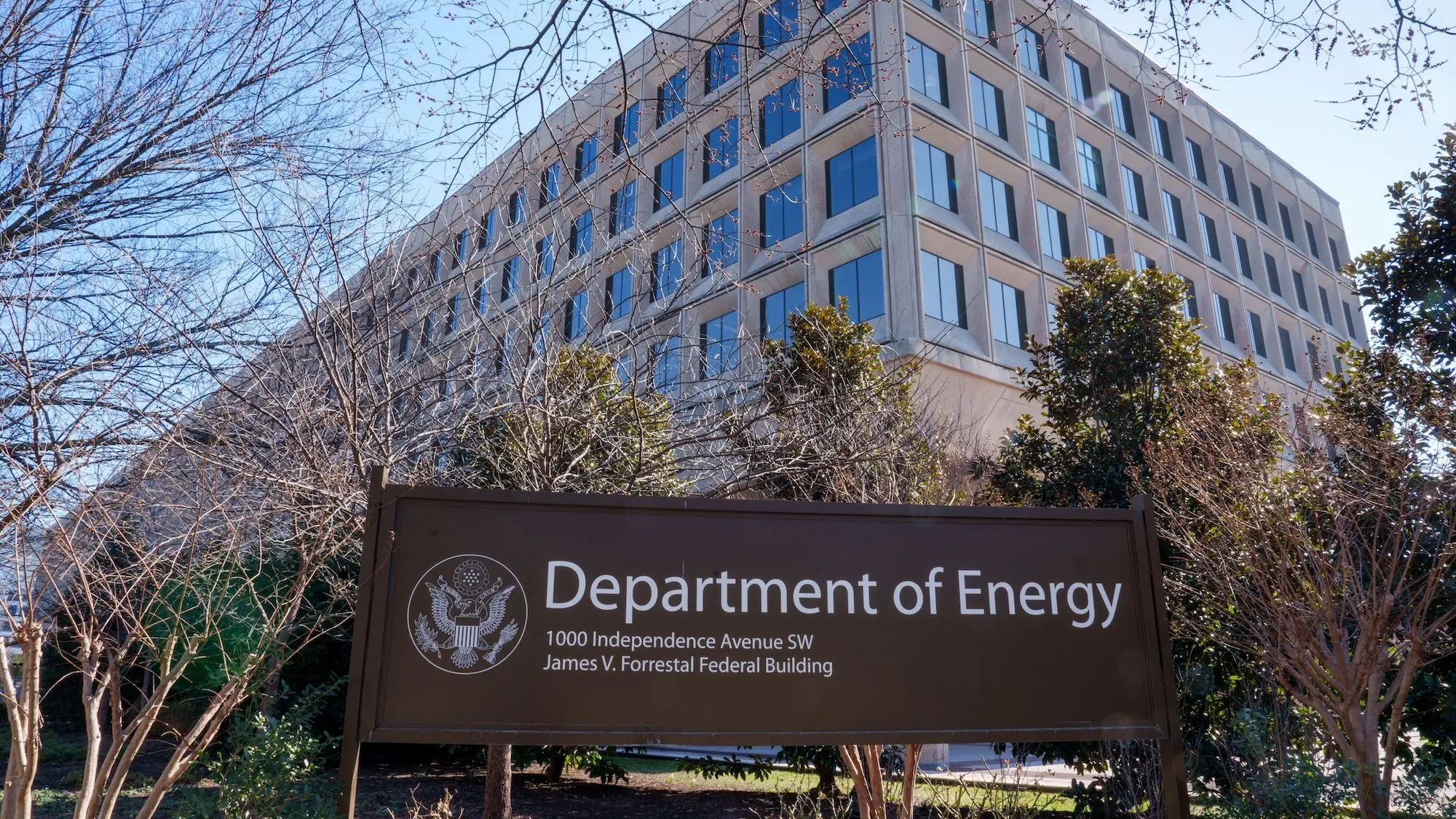مبنى وزارة الطاقة الأمريكية، مع لافتة تحمل اسم الوزارة، يظهر في الصورة مع أشجار في المقدمة.