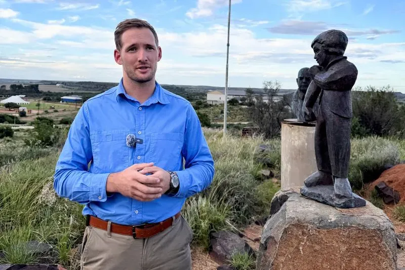 شخص يقف أمام تمثال في أورانيا، مستوطنة أفريكانية في جنوب أفريقيا، يتحدث عن سعيهم لتقرير المصير والاعتراف كدولة مستقلة.