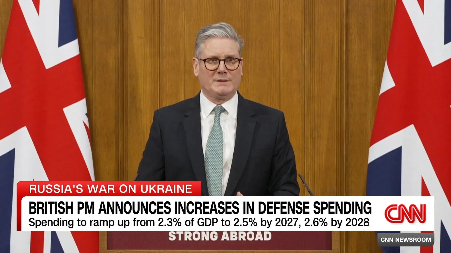 كير ستارمر، رئيس الوزراء البريطاني، يتحدث في مؤتمر صحفي عن زيادة الإنفاق الدفاعي، مع العلم بعلم المملكة المتحدة خلفه.