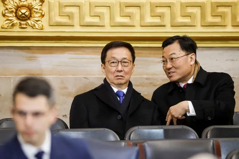 رجلان يجلسان في قاعة رسمية، أحدهما يبدو جادًا والآخر يتحدث إليه. تعكس تعابير الوجه التوتر السياسي حول مستقبل تطبيق تيك توك.